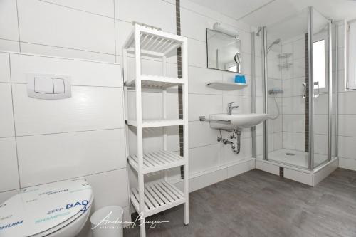 a white bathroom with a sink and a toilet at Haus-Herrmann-1 in Borkum