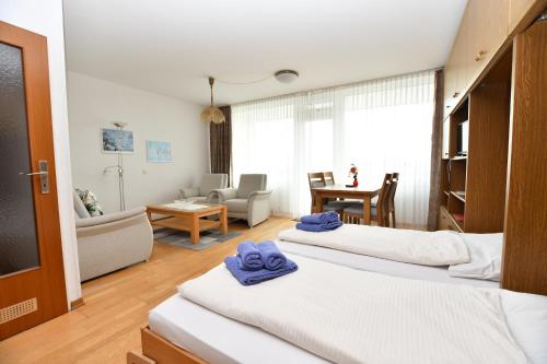 een slaapkamer met 2 bedden en een woonkamer bij Haus-Seeblick-43 in Borkum