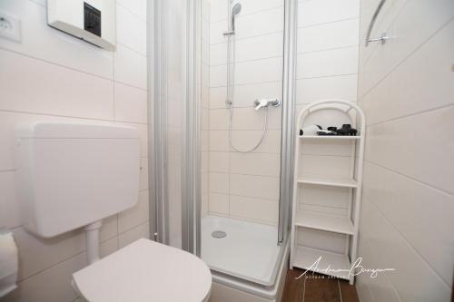 ボルクムにあるHaus Moewennest I/ Ankerplatzの白いバスルーム(シャワー、トイレ付)