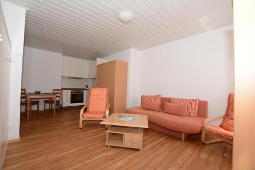 ein Wohnzimmer mit einem Sofa, Stühlen und einem Tisch in der Unterkunft "Gästehaus Flandern" 2 in Borkum