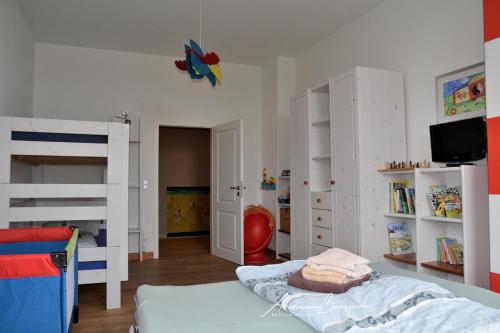 ボルクムにあるVilla-Emilie-Wohnung-Augustineのベッドルーム1室(二段ベッド2台、テレビ付)