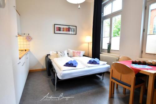 Kleines Zimmer mit einem Bett und einem Tisch in der Unterkunft Gästehaus St. Josef 2 in Borkum