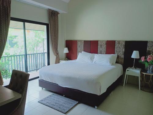 sypialnia z dużym łóżkiem i balkonem w obiekcie Sri Ngachang w mieście Chiang Mai