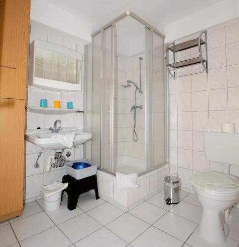 ein Bad mit einer Dusche, einem Waschbecken und einem WC in der Unterkunft Haus Königsdüne I/2 in Borkum