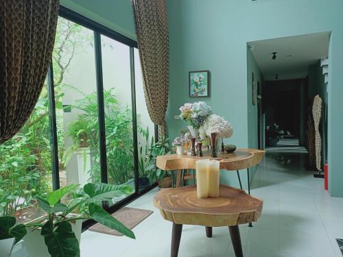 una sala de estar con una mesa con flores. en Sri Ngachang, en Chiang Mai