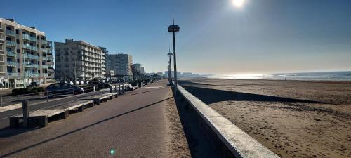 - une plage avec des bancs et un éclairage de rue dans l'établissement Face estacade, studio 4 personnes vue mer, à Saint-Jean-de-Monts