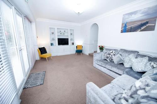 a living room with a couch and a tv at Garden by the Bay Southport in Southport