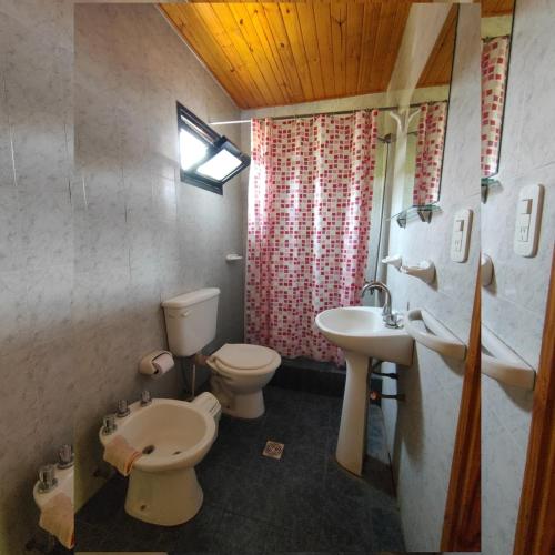 a bathroom with a toilet and a sink and a toilet istg at Cabañas Las Delicias in Coronel Moldes