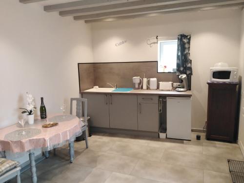 eine Küche mit einem Tisch und einer Arbeitsplatte in der Unterkunft La Maisonnette de Gallerie in Cour-Cheverny