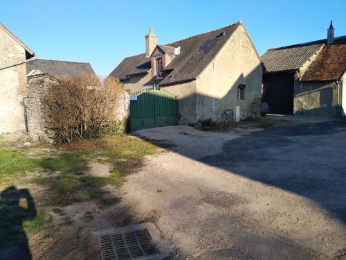 un groupe de maisons avec un portail vert et une allée dans l'établissement La Maisonnette de Gallerie, à Cour-Cheverny