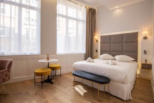 里爾的住宿－Les Suites Faidherbe，一间卧室设有一张大床和两个窗户。