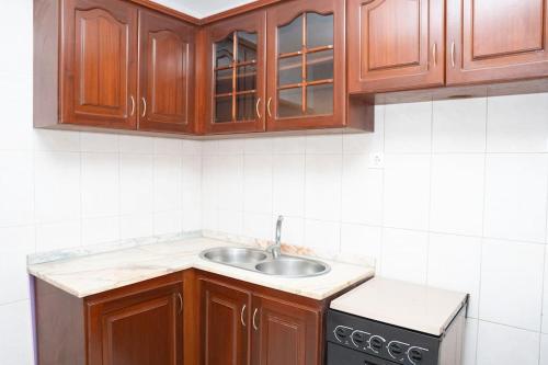 eine Küche mit Holzschränken und einem Waschbecken in der Unterkunft 3 bedroom apt, near city center, Assomada - LCGR in Assomada