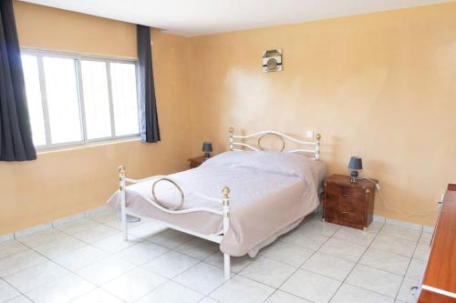 ein Schlafzimmer mit einem weißen Bett und einem Fenster in der Unterkunft 3 bedroom apt, near city center, Assomada - LCGR in Assomada