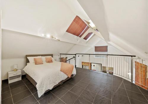 an attic bedroom with a bed and a staircase at Parking, Heated floors, Sleeps 4 guests, Netflix in Lincoln