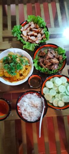 a table with different plates of food on it at Charm's Homestay in Phong Nha