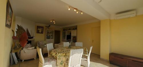 une salle à manger avec une table et des chaises blanches dans l'établissement Port Frejus 1er etage de villa vue sur mer, 8-9 Pe, à Fréjus