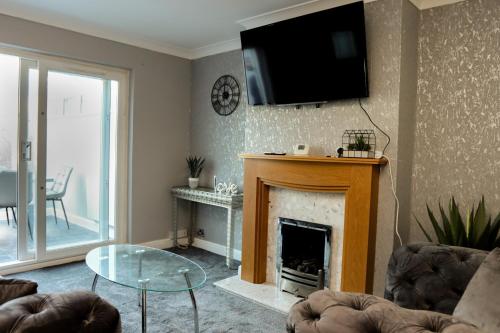 sala de estar con chimenea y TV en la pared en The Grey Haven Birmingham, en Birmingham
