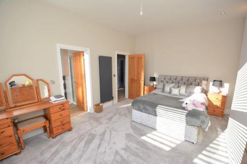 a bedroom with a bed and a desk and a piano at Modern luxury home in Wallasey