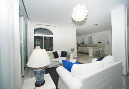 Una sala de estar con dos sofás blancos y una lámpara. en Casa Kasima for family gatherings, en Cabopino