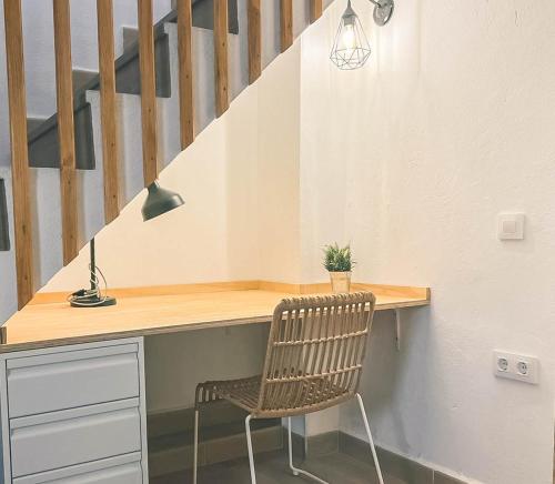 a desk with a chair next to a staircase at Casa Rural El cerrillo in Abrucena