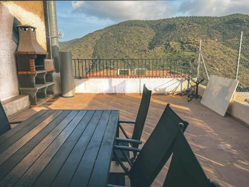 una mesa de madera y una silla en un balcón con una montaña en Casa Rural El cerrillo, en Abrucena