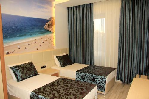 Una habitación de hotel con dos camas y vistas a la playa. en Ark Apart and Suite Hotel, en Alanya