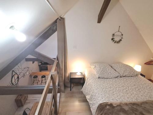 a bedroom with a bed and a staircase in a room at Loft proche des plages et sites du débarquement in Osmanville