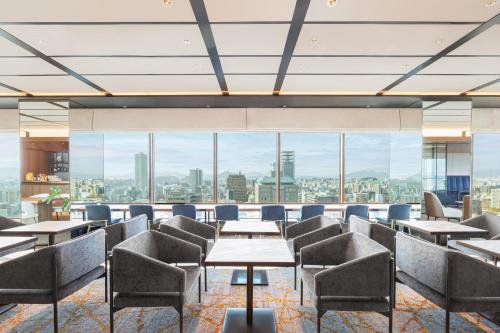 a restaurant with tables and chairs and a view of the city at ANA Crowne Plaza Hiroshima, an IHG Hotel in Hiroshima