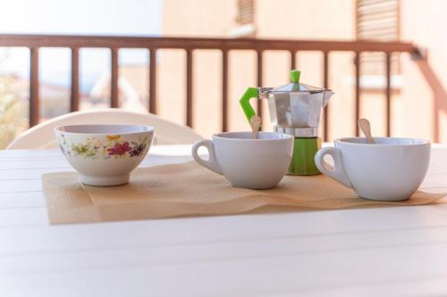 three cups sitting on a table with a juicer at La Basoledda in Isola Rossa