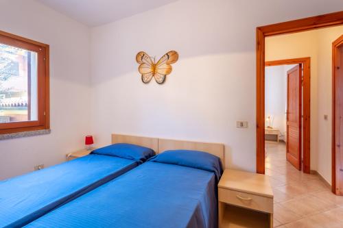 a bedroom with two beds and a butterfly clock on the wall at La Basoledda in Isola Rossa
