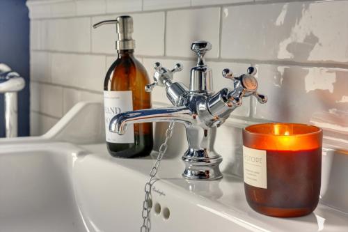 a sink with a candle and a bottle of wine at 2 Bedroom Terrace House in Bedford by SILVA in Bedford