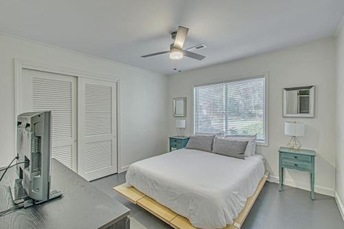 a bedroom with a bed and a desk with a computer at The Nathalie - curated, open, tree covered family in Charleston