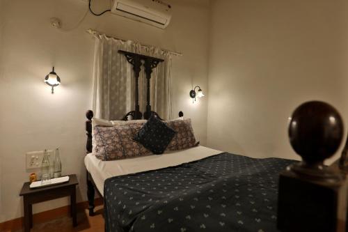 a bedroom with a bed with pillows on it at Caju Grove - The Big Yellow Goan House in Guirim
