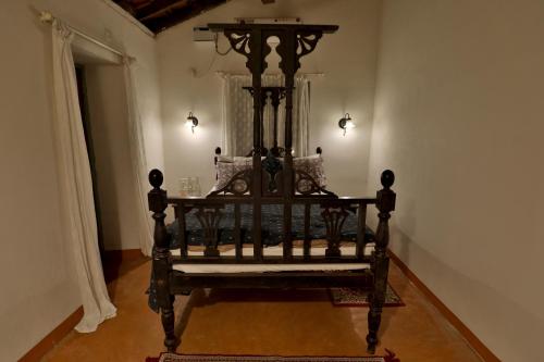 a black bed in a room with lights on at Caju Grove - The Big Yellow Goan House in Guirim