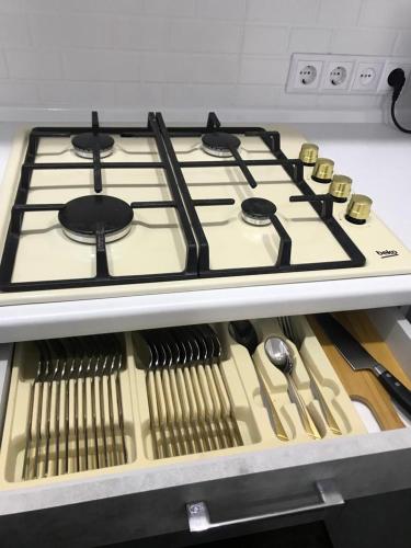 a stove top in a kitchen with some utensils at Люкс в центре Караганды in Karagandy