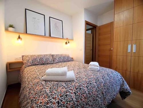 - une chambre avec un lit et des serviettes dans l'établissement A casiña de Luz, à Pontevedra