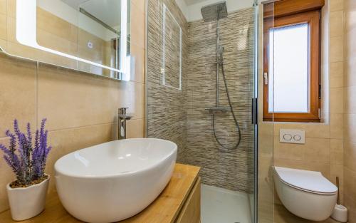 een badkamer met een witte wastafel en een douche bij Apartment Blue Pula, New, Family friendly, Comfortable, free parking and WiFi in Pula