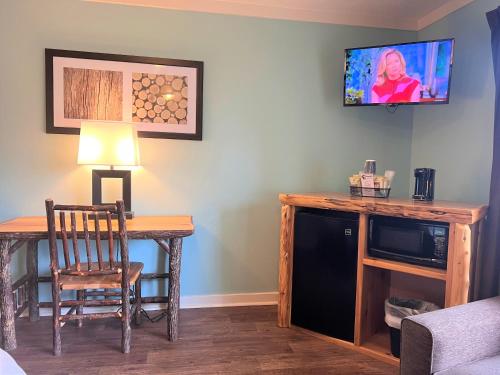 a room with a desk with a chair and a tv at Mountain Top Inn and Resort in Warm Springs