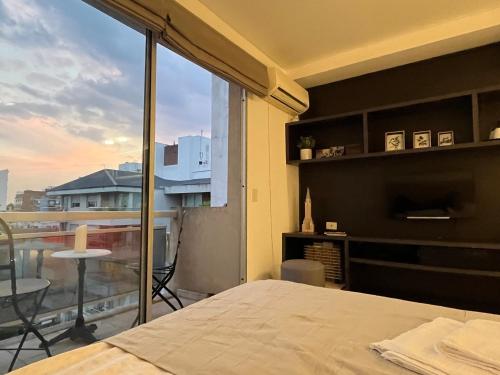 Schlafzimmer mit einem Bett und Blick auf einen Balkon in der Unterkunft Departamento en Castelar in Castelar