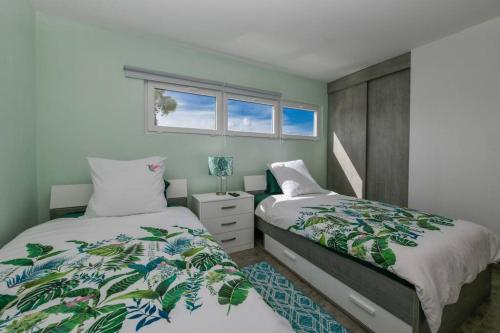 1 dormitorio con 2 camas y ventana en Beach Dream Island House en Oranjestad