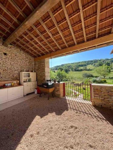 une grande cuisine extérieure avec vue sur un champ dans l'établissement Le Pied du Loup - gîte proche Cluny au calme 6-7 personnes, à Flagy