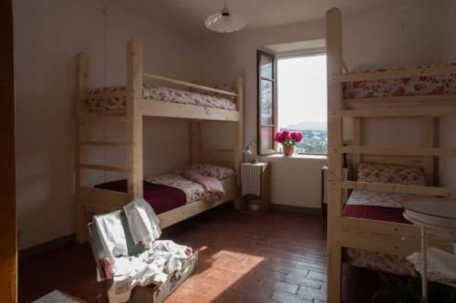 a bedroom with two bunk beds and a window at Casa riservata sulle colline di Parma oasi di pace in Neviano degli Arduini