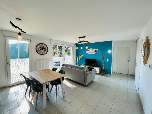 un salon avec une table et un canapé dans l'établissement L'océan, T3 neuf 300m de la mer classé 3 étoiles, à Saint-Jean-de-Monts
