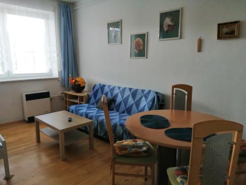 a living room with a blue couch and a table at Ubytování Eva in Luhačovice
