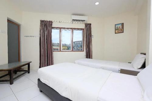 a bedroom with two beds and a window at Q Hotel Temerloh in Temerloh