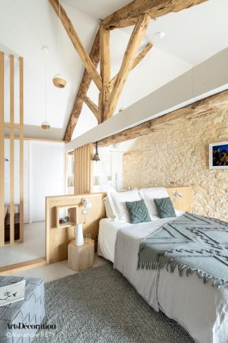 une chambre avec un grand lit et un mur de briques dans l'établissement Hors-série en Périgord, à Millac