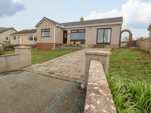 a house with a brick driveway in front of it at Awelfryn in Rhosneigr