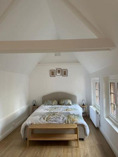 une chambre avec un lit dans une pièce blanche dans l'établissement Nouveau! La p tite maison sur le port, Maison de pêcheurs, rénovée, à Saint-Valery-en-Caux