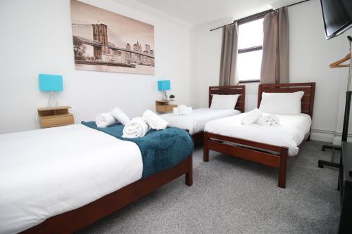 a room with three beds and a window at Modern 2 Bedroom Flat in Robert st, Swansea in Swansea