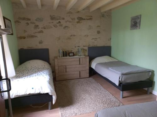 - une chambre avec 2 lits jumeaux et une commode dans l'établissement Les Deux Sapins, à La Châtre-Langlin